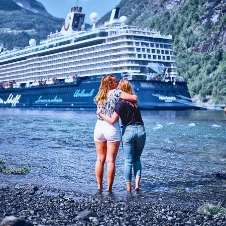 Crew-Mitglieder auf Landgang umarmen sich mit Blick auf Mein Schiff 5