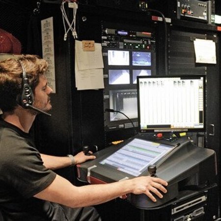Bühnentechniker sitzen beisammen und bereiten eine Show am Computer vor