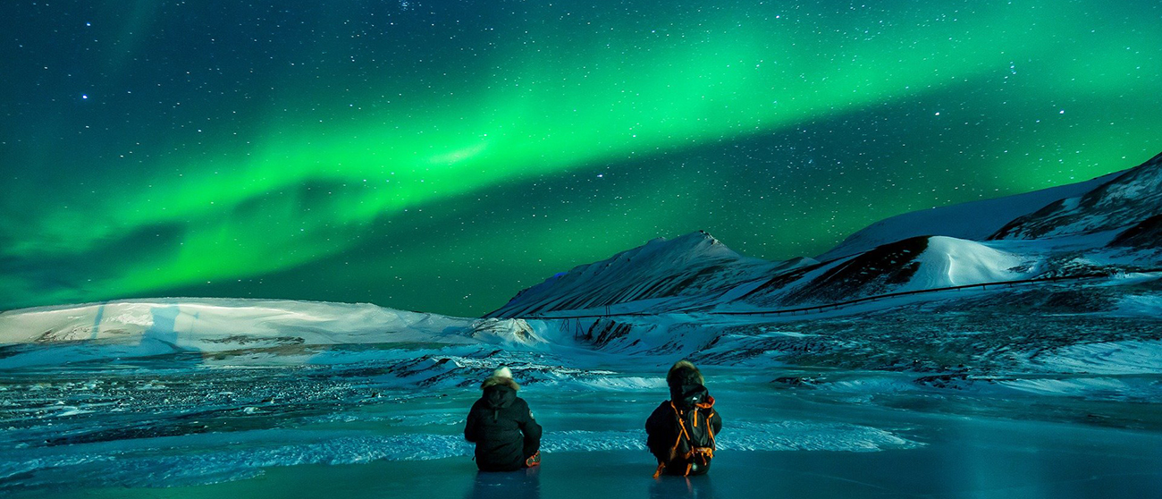 Polarlichter über Eisbergen am Meer