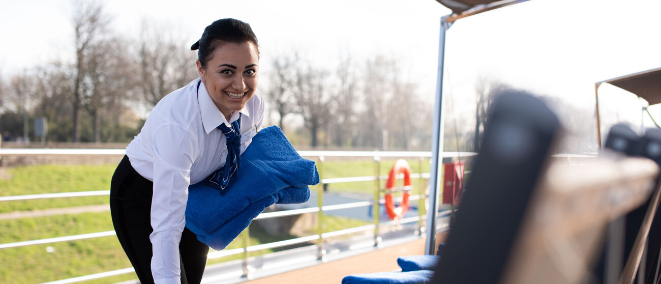 Housekeeping Crew bereitet das Sonnendeck eines Flusskreuzfahrtschiffes vor und verteilt Handtücher