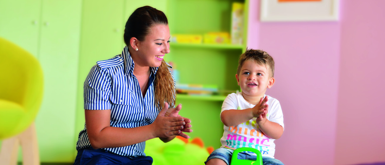 Kinderbetreuuerin spielt mit einem Kind auf der Mein Schiff