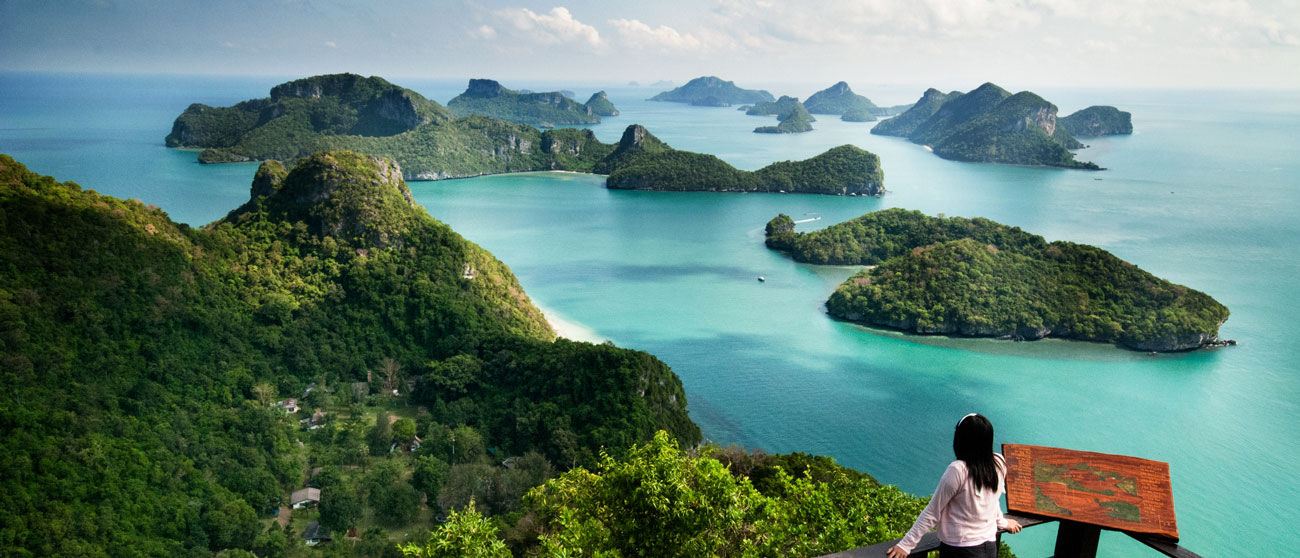 Crew Mitglied steht auf einem Berg in Thailand und schaut auf Inseln herunter