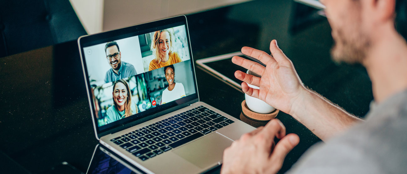 Mann am Laptop spricht mit vier weiteren Personen via Videochat