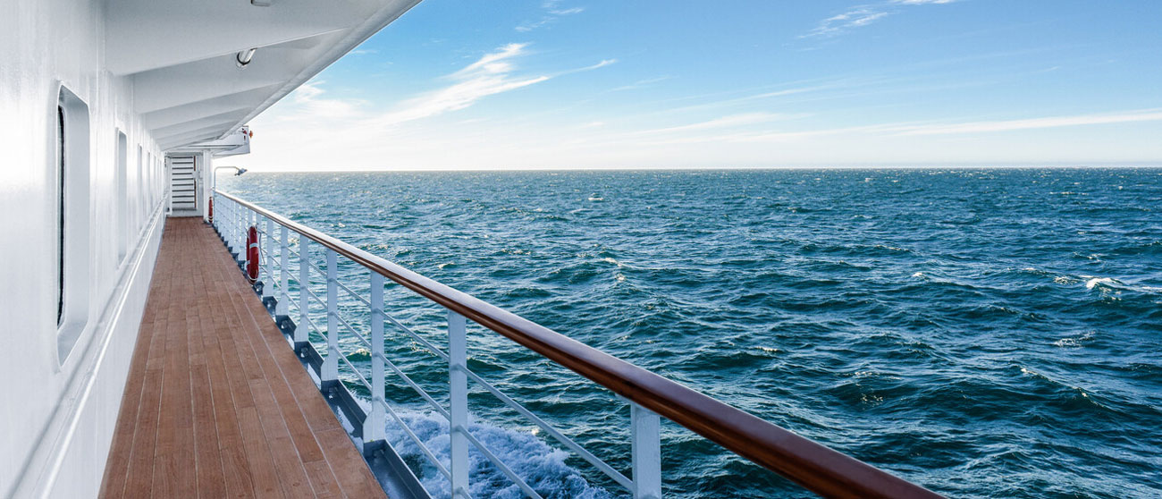 Blick über die Reling eines Kreuzfahrtschiffes von Hapag-Lloyd Cruises auf eine raue See