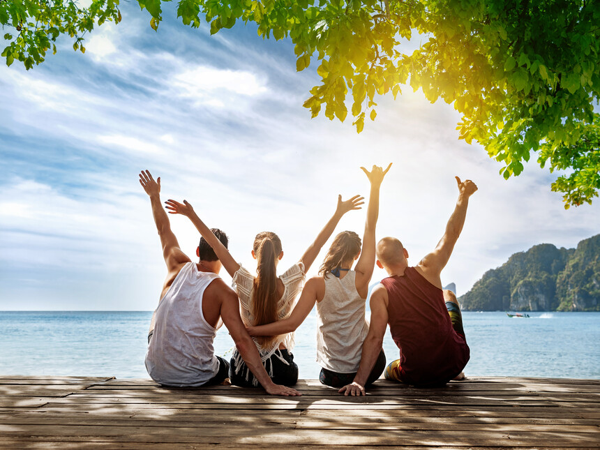 Crew Mitglieder sitzen am Strand mit Kollegen