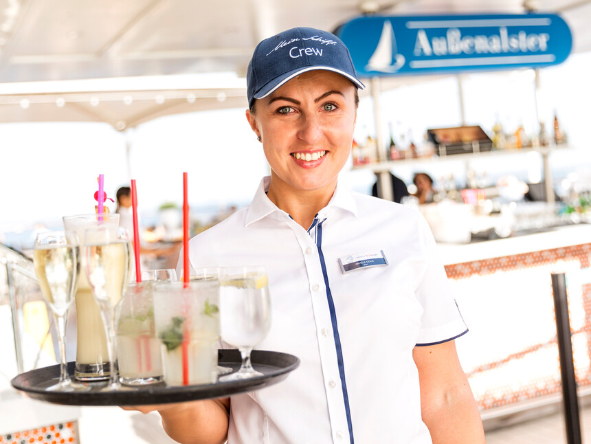 Barkeeper auf Mein Schiff serviert Drinks an der Bar "Außenalster"