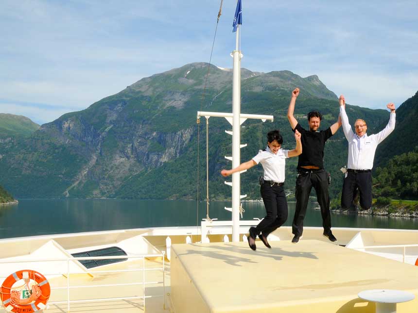 Crew auf dem Crewdeck im Hintergrund die Fjordlandschaft