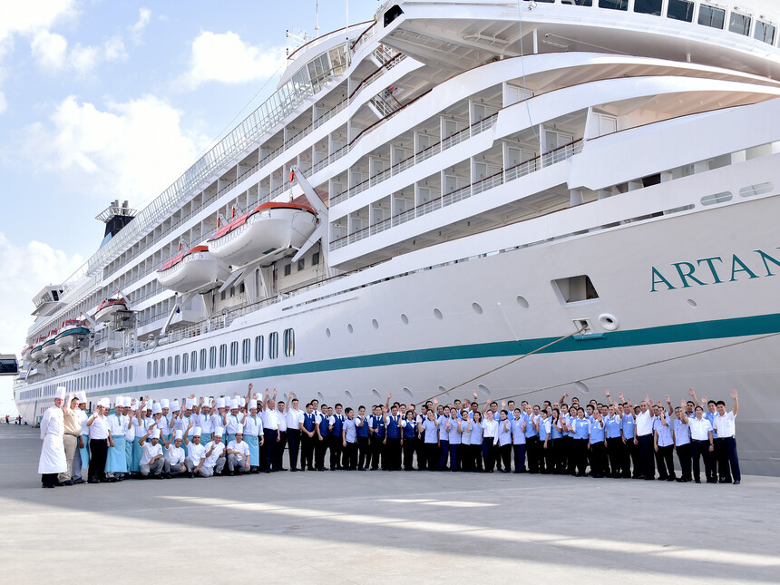 Gruppenbild der Crew von MS Artania an der Pier vor dem Schiff