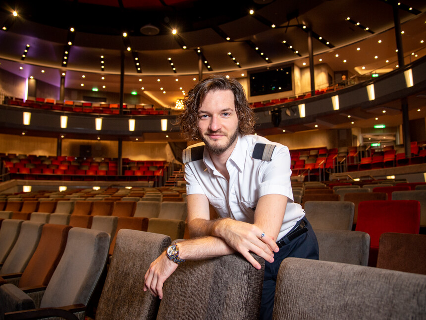 Musikalischer Leiter auf Mein Schiff im Theater an Bord lehnt sich über Sitz