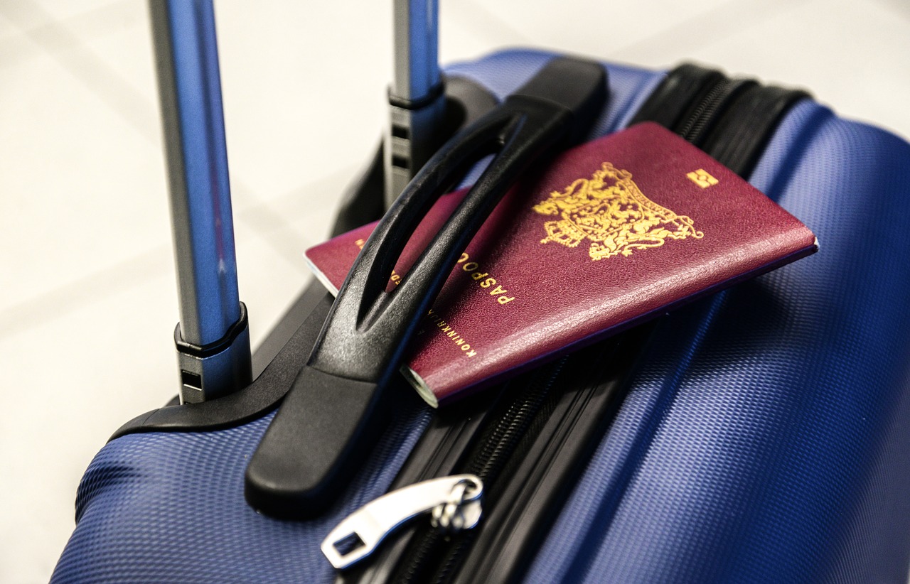 Reisepass liegt auf blauem Koffer
