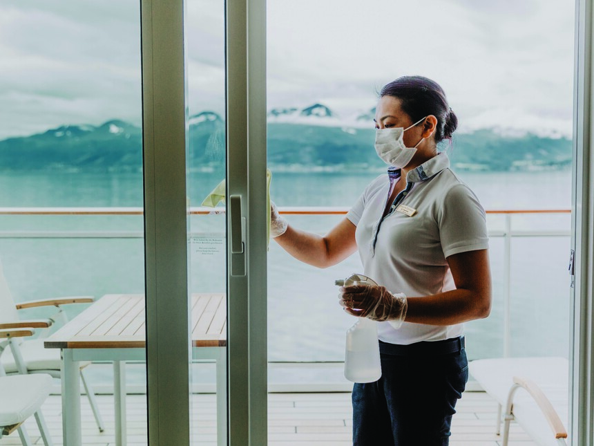 Housekeeping desifiziert Kontaktflächen an der Balkontür einer Suite