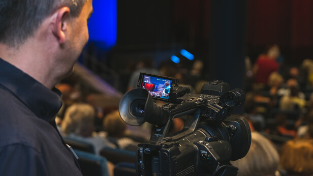 Medientechniker nimmt eine Show mit einer Videokamera auf