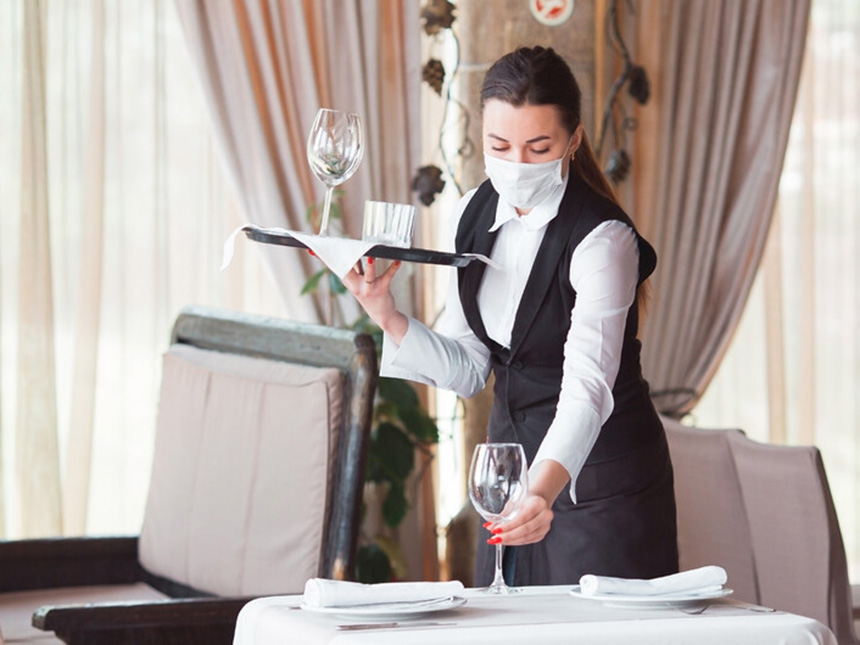 [Translate to English:] Einhaltung der Hygienevorschriften an Bord - Frau mit Maske im Service