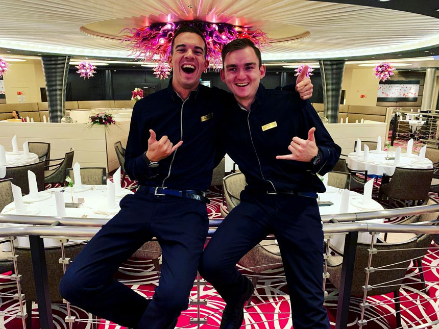 Service Crew-Mitglieder auf MS EUROPA stehen in Restaurant und umarmen sich